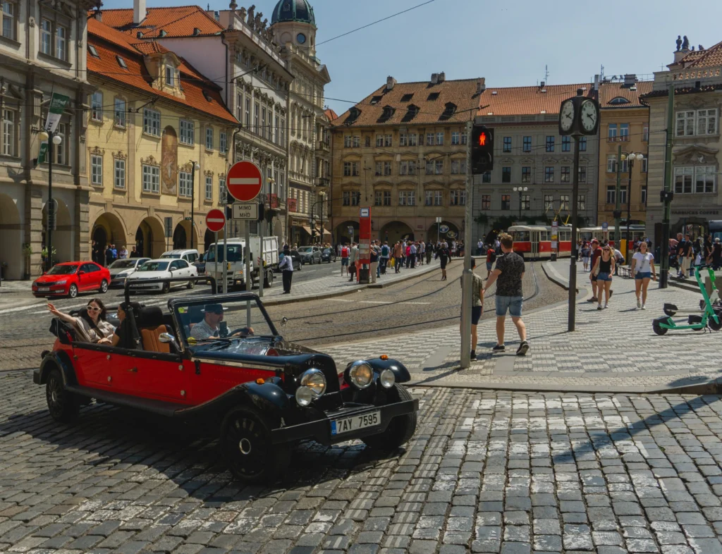 Czerwono-czarny stary samochód na ulicach centrum miasta.