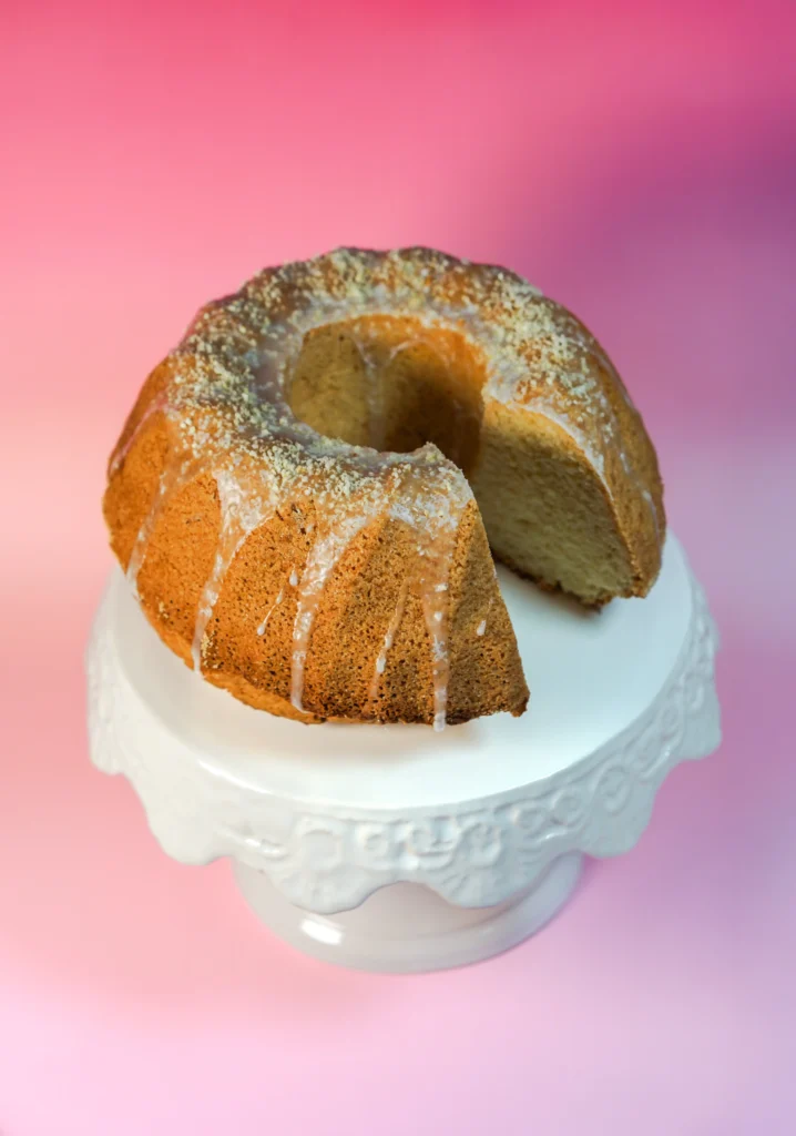 Babka drożdżowa z odkrojonym kawałkiem na specjalnej tacy.